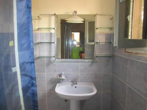 a bathroom with a sink and a mirror at La Femme Noire in Joal-Fadiout