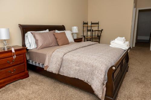 una camera con letto e comò in legno con comodino di CityStay a Baltimora