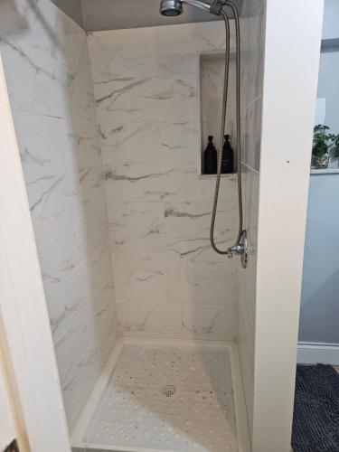 ein Bad mit einer Dusche mit weißem Marmor in der Unterkunft The Vacay Inn in Lauderdale Lakes