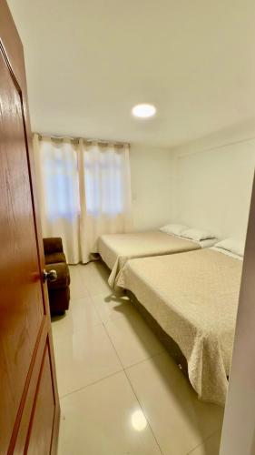 Zimmer mit 2 Betten und einer Tür mit einer Tür in der Unterkunft Departamento completo en el primer piso in Ayacucho