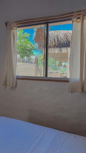 a bedroom window with a view of a beach at Kinti Beach Mancora in Máncora