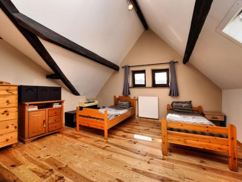 une chambre mansardée avec deux lits et du parquet dans l'établissement Villa with Spa, Luxembourg, à Érezée