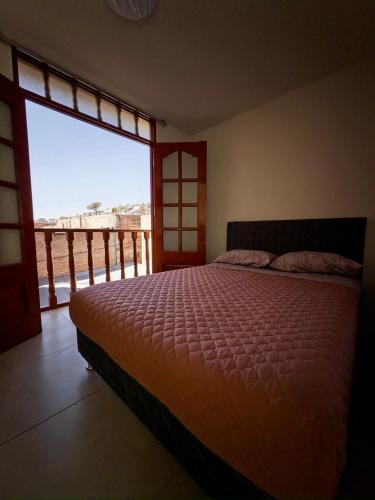 a bedroom with a bed and a large window at Habitación con Balcón Castellares La Puebla in Ayacucho