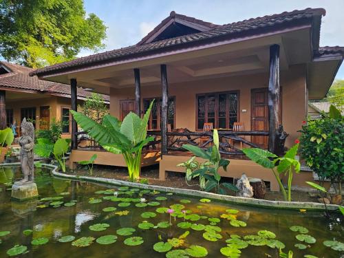 a house with a koi pond in front of it at ลันตาไวท์ร็อก รีสอร์ท in Ban Nong Chaeng