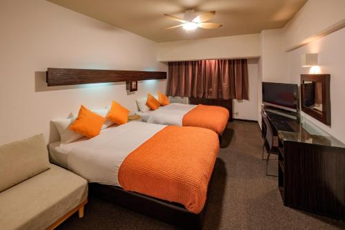 une chambre d'hôtel avec deux lits et un canapé dans l'établissement Miyazaki Mango Hotel - Vacation STAY 58300v, à Miyazaki