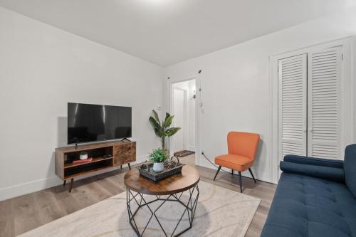 a living room with a blue couch and a tv at Downtown Hartford 2BR Family Pet Friendly in Hartford