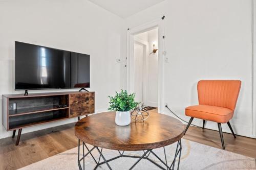 a living room with a table and a chair and a television at Downtown Hartford 2BR Family Pet Friendly in Hartford