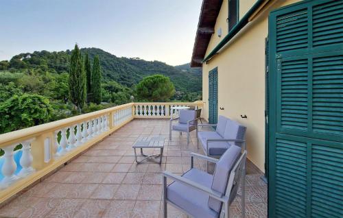 a balcony with chairs and a table and mountains at Stunning Home In Camporosso in Camporosso