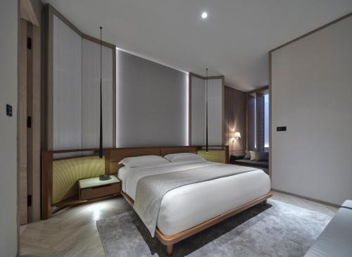 Un dormitorio con una gran cama blanca. en Soori Penang, en George Town