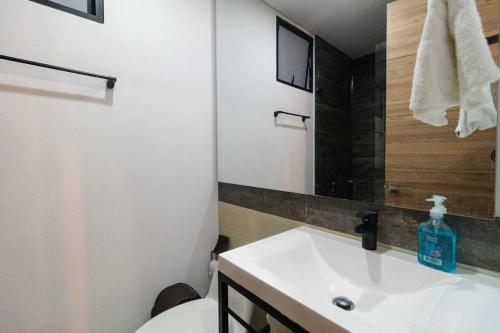 a bathroom with a sink and a toilet and a mirror at Fabuloso apartamento en el Mar Caribe - Rodadero in Gaira