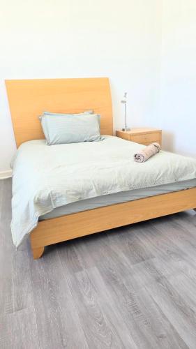 a bed with a wooden headboard in a bedroom at room near train station and airport in Perth