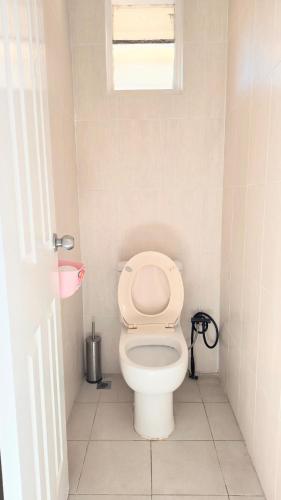 a bathroom with a white toilet with a window at room near train station and airport in Perth