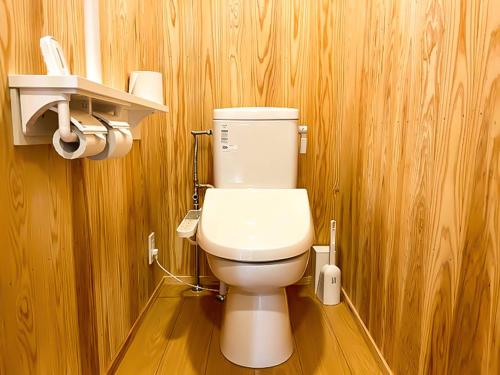 uma casa de banho com um WC branco numa parede de madeira em Irori no oyado zen - Vacation STAY 80209v em Mimasaka