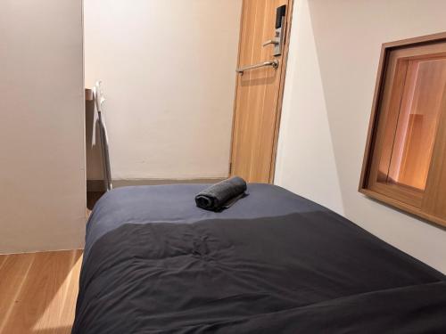 a bed in a room with a black pillow on it at Althia Capsule Quarters in Badung