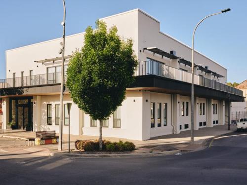 a white building with a tree in front of it at Thirty Nine Alexander in Port Pirie