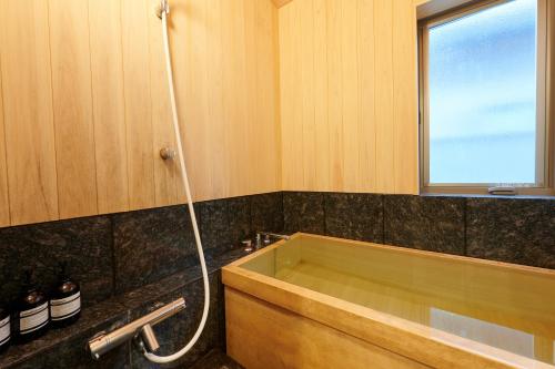 a bathroom with a bath tub and a window at なぎさホテル in Zushi