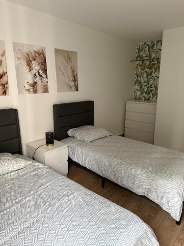 Modern and cozy 2 bedroom fully equipped في أولينز: سريرين في غرفة مع سريرين sidx sidx