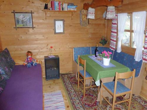ein Raum mit einem Tisch und einer Puppe, die an einem Tisch sitzt in der Unterkunft Rural Home Near Bavarian Lakes in Steingädele