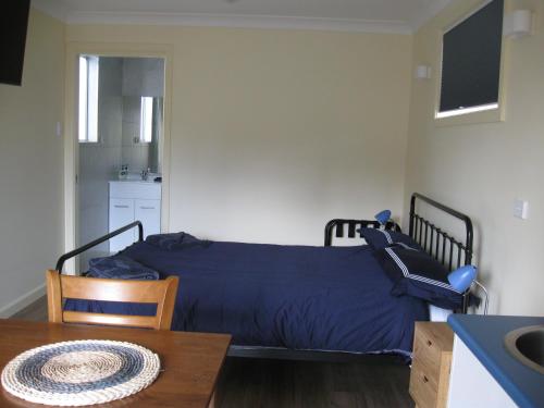 ein Schlafzimmer mit einem Bett mit einem Tisch und einem Esszimmer in der Unterkunft Delegate Studio Cabin in Delegate