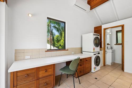 Noosa Retreat. Ocean Views, Pool and Serenity في نوسا هيدز: مطبخ مع كونتر وغسالة ومجفف