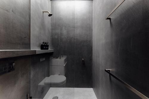 a bathroom with a toilet and a glass shower at The Lookout - a Huch experience in Wollombi