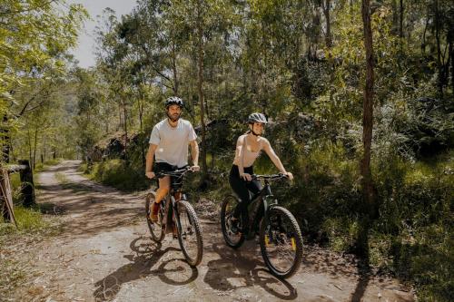two people riding bikes on a dirt trail at The Lookout - a Huch experience in Wollombi