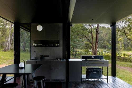 a kitchen and dining area of a house with a large window at The Lookout - a Huch experience in Wollombi