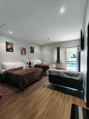 a hotel room with two beds and a couch at birdwatchers beachfront hotel panglao in Panglao Island