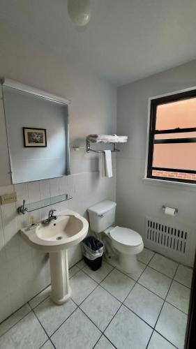 a white bathroom with a sink and a toilet at Chinatown Hotel Chicago in Chicago