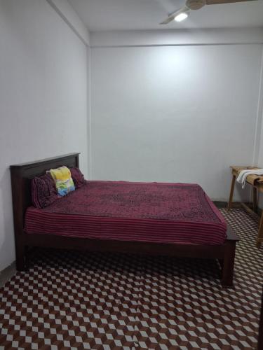 a bedroom with a bed with a red bedspread at Trintrip Residence in Trincomalee