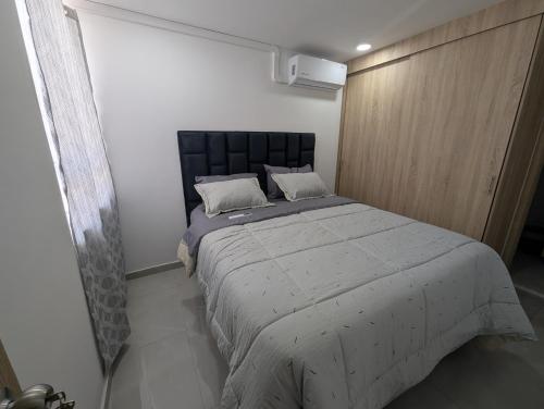 una camera da letto con un letto grande in una stanza di acogedor Apartamento en el centro de Cali, cerca a todo a Cali