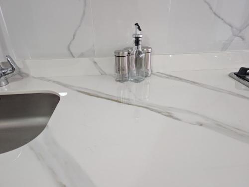 un lavandino bianco del bagno con due rubinetti sopra di acogedor Apartamento en el centro de Cali, cerca a todo a Cali