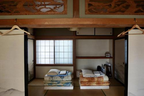 2 Etagenbetten in einem Zimmer mit Fenstern in der Unterkunft 八戸ゲストハウス トセノイエ / Hachinohe Guest House Tosenoie in Hachinohe