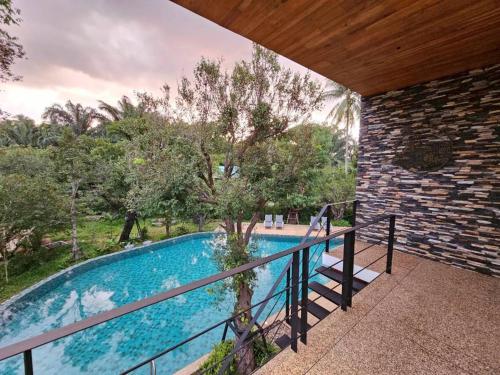 Una vista de una piscina desde un balcón. en Khanom Station 549, en Ban Na Dan