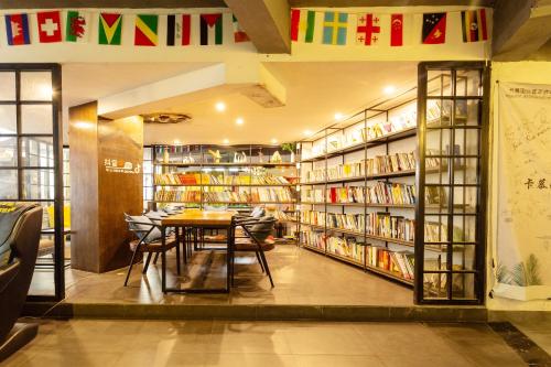 a dining room with a table and bookshelves at Zhangjiajie Yeah Hostel in Zhangjiajie