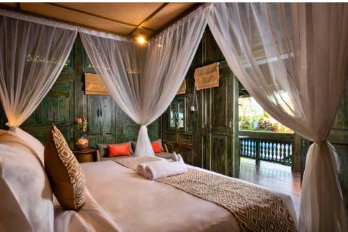 En eller flere senge i et værelse på Kumara Wooden House 3 BR Shared Pool View ZN376