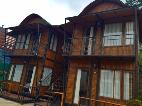a large wooden building with a staircase in front of it at Mitaree Hotel 1 in Mae Sariang