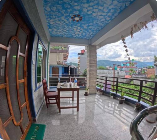 Habitación con mesa y balcón con vistas. en Pokhara Apartment CS, en Pokhara