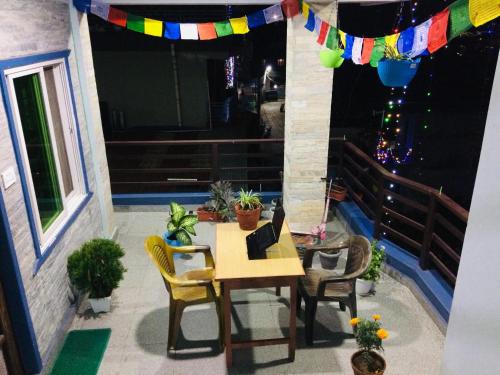 Un patio con una mesa y sillas en un balcón. en Pokhara Apartment CS, en Pokhara