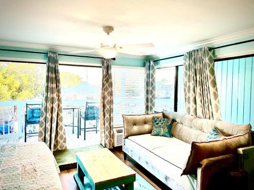 a living room with a couch and a large window at Cedar Key Islands Dolphins Cay Condo in Cedar Key