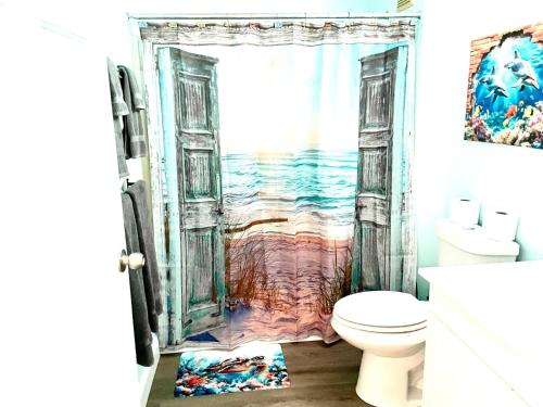 an open bathroom door with a painting of the ocean at Cedar Key Islands Dolphins Cay Condo in Cedar Key