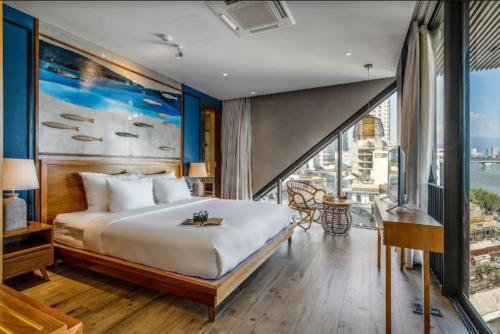 um quarto com uma cama grande e uma janela grande em Riverside Seahorse Danang Hotel em Da Nang