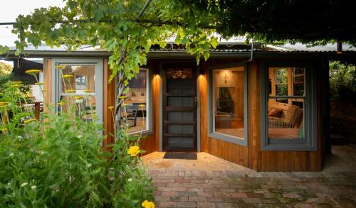 a house with a wooden door and windows at Delphi, Adelaide Hills Garden BnB in Mylor
