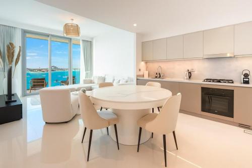a kitchen and dining room with a white table and chairs at Pure Voyage Beachfront in Dubai