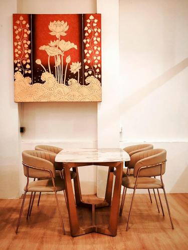 a dining room table and chairs with a painting on the wall at Pineapple Residence Pattaya in Pattaya