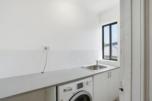 WarraneHobart Family Home near Airport & City的带水槽和洗衣机的厨房