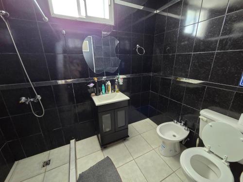 a bathroom with a toilet and a sink and a mirror at Alisos Suite FC Torre 2 in El Ceibal