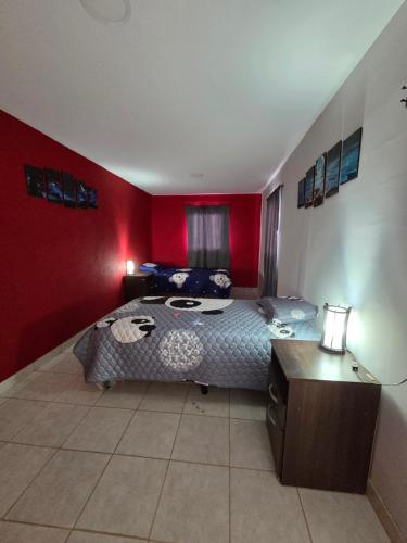 a bedroom with a bed and a red wall at Alisos Suite FC Torre 2 in El Ceibal