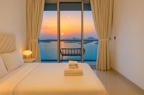 a bedroom with a bed with a view of the ocean at Pure Voyage Beachfront in Dubai