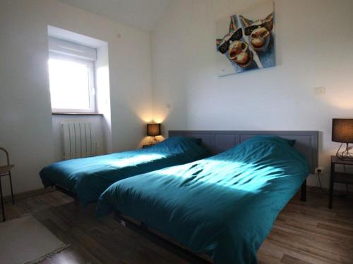 deux lits dans une chambre avec des draps bleus dans l'établissement Charmante maison mitoyenne avec jardin et Wifi en campagne près de Nantes - FR-1-306-1320, à Bouvron